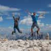 Zwei springende Personen vor Bergpanorama